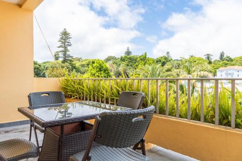 a patio with a table and chairs on a balcony at Apartamento Mãe de Deus in Ponta Delgada