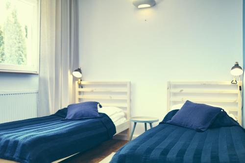 two beds sitting next to each other in a bedroom at COZYWOOD Domki wypoczynkowe z balią i sauną na Kaszubach in Pomlewo