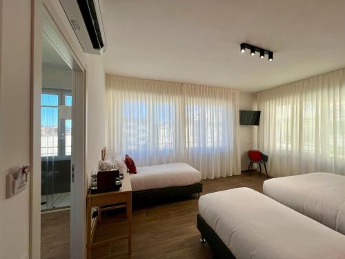 ein Hotelzimmer mit zwei Betten und einem Fenster in der Unterkunft Florentia Boutique in Florenz