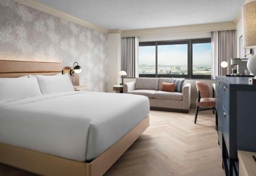 a hotel room with a bed and a couch at Sonesta Los Angeles Airport LAX in Los Angeles