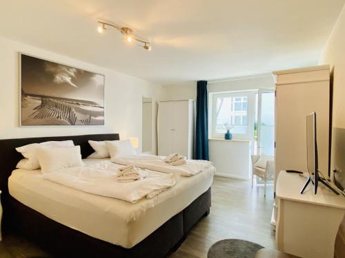 a bedroom with a large bed with white sheets at Ferienwohnung Maritimus Haus Strandbummler Baabe in Baabe