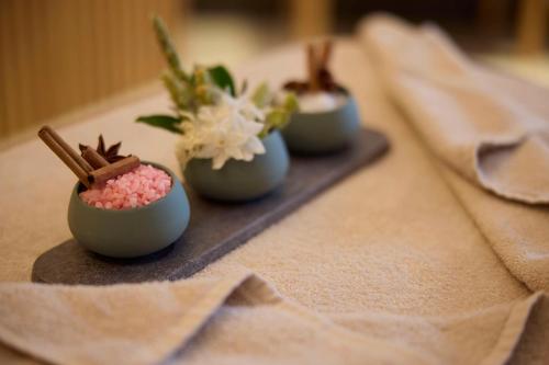 a table with three small dishes with flowers in them at Dusit Suites Hotel Athens in Athens