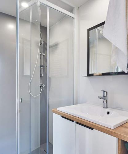 une salle de bain avec un lavabo et une douche dans l'établissement Mobile-home bord de mer, au Guilvinec