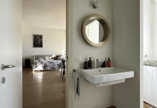 a bathroom with a white sink and a mirror at LA TERRAZZA VISTA DUOMO, piscina e campi da tennis in Milan