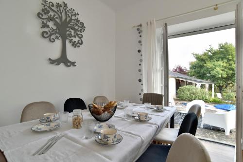 une salle à manger avec une table et une grande fenêtre dans l'établissement Le Clos Marin - Belle maison avec Dépendance, à Saint-Cast-le-Guildo