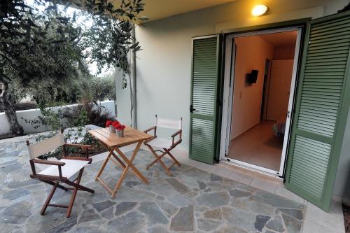 a patio with a wooden table and chairs at Athena Villas Olive Grove & Estate in Gouves