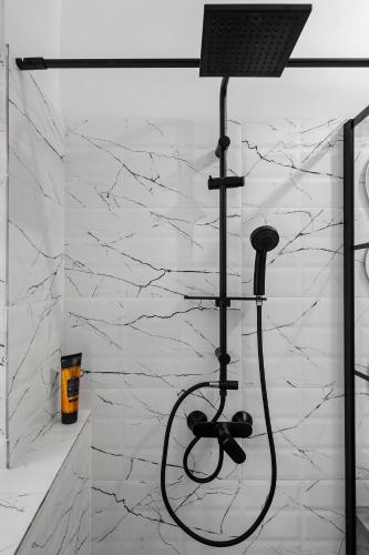 a shower in a bathroom with white marble walls at SEVEN Apartments in Predeal