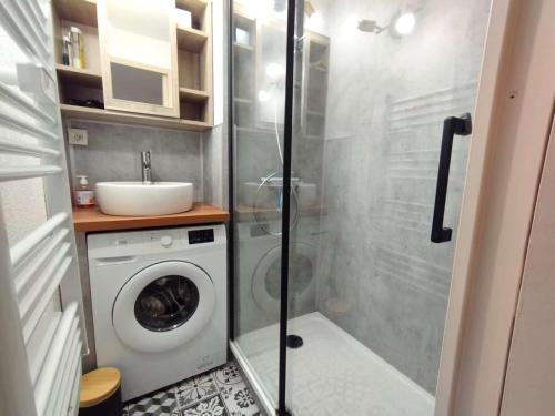 une salle de bain avec une machine à laver et un lavabo dans l'établissement Appartement T3 pour 6 à Vignec avec terrasse, parking et casier à skis - FR-1-457-346, à Vignec