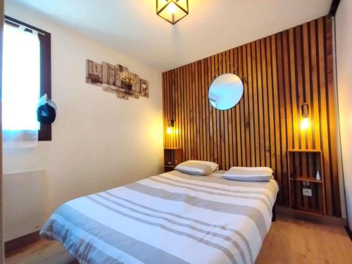 une chambre avec un grand lit avec un mur en bois dans l'établissement Appartement T3 pour 6 à Vignec avec terrasse, parking et casier à skis - FR-1-457-346, à Vignec