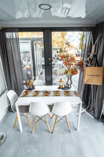 a white table and chairs in a room with a window at Cozy houseboat near Giethoorn in Zwartsluis