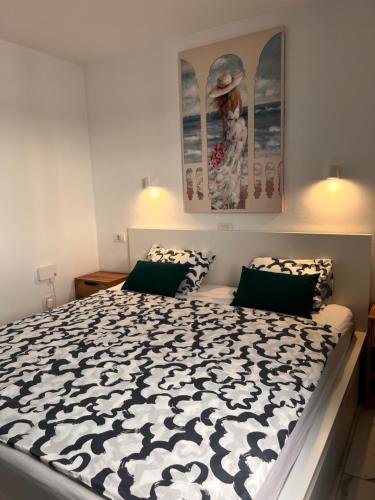 a bedroom with a bed with a black and white comforter at TK OCEANVIEW Apartment in Puerto del Carmen