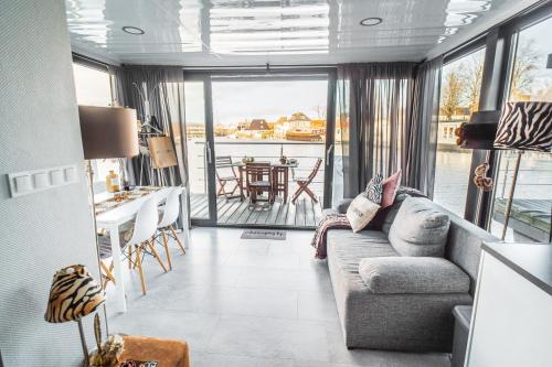 a living room with a couch and a table at Cozy houseboat near Giethoorn in Zwartsluis