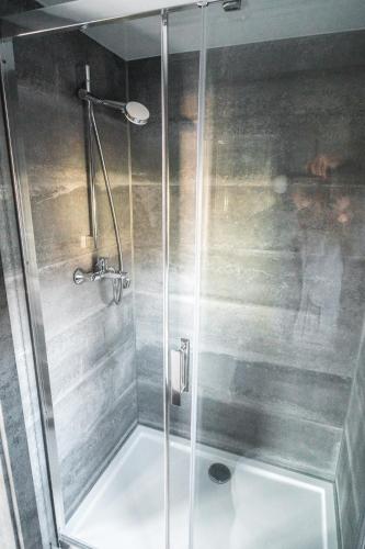 a shower with a glass door in a bathroom at Cozy houseboat near Giethoorn in Zwartsluis