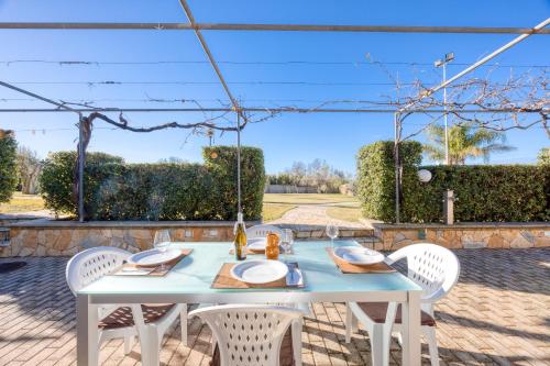 a white table and chairs on a patio with a pergola at Residence Margherita in Ugento
