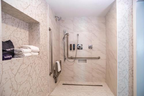a bathroom with a shower with a phone and towels at Old Orchard Inn in Wolfville