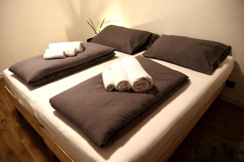 two beds with towels and pillows on them at Residenza famiglia Moser - Chalet Olimpico 2026 in Pergine Valsugana