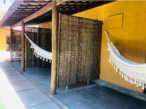 a room with hammocks on the side of a building at Sunshine Pousada in Japaratinga
