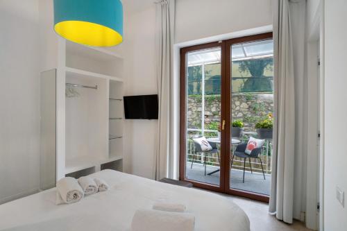 a bedroom with a bed and a balcony with a table at Luxury Villa La Balena Blu in Massa Lubrense