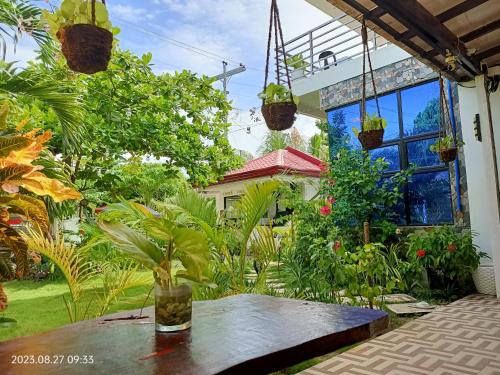 a patio with a table in a garden with plants at CHIEF'S VILLA Rentals Malapascua Island in Malapascua Island