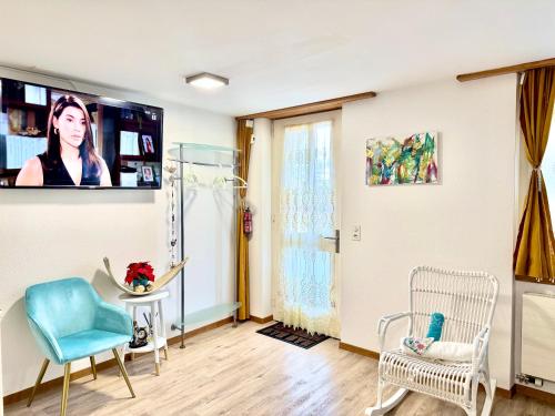 a living room with a tv on the wall at Haus Caeli - Gemütlich im Zürcher Unterland in Wil