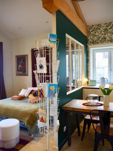 - une chambre avec un lit et une table dans l'établissement Le Nid d Aulesaje, à Ville-sur-Jarnioux