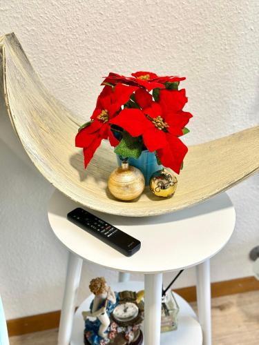 a vase with red flowers on top of a shelf at Haus Caeli - Gemütlich im Zürcher Unterland in Wil