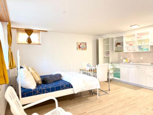 a bedroom with a bed and a kitchen at Haus Caeli - Gemütlich im Zürcher Unterland in Wil