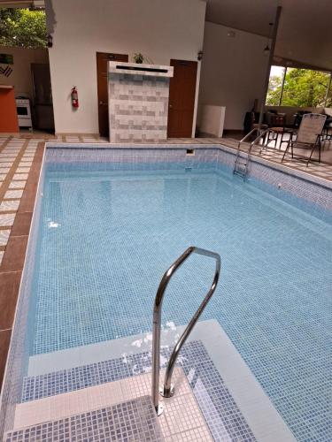 a large swimming pool with a metal stair in it at Hotel San Rafael Ecolodge in San Gerardo