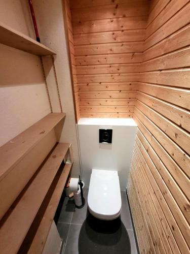 une petite salle de bain avec toilettes dans un mur en bois dans l'établissement Bel appartement Lagny sur Marne, à Lagny-sur-Marne