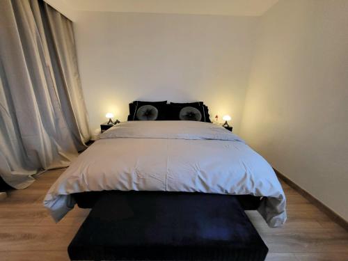 a bedroom with a bed with a black head board at Bel appartement Lagny sur Marne in Lagny
