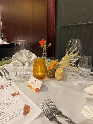 a table with wine glasses and vegetables on it at L'Hôtel et Restaurant du Golf de Clervaux in Eselborn