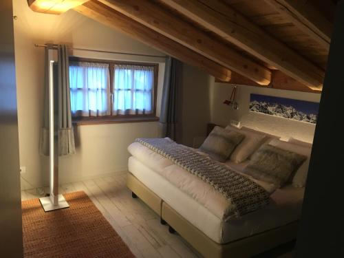 a bedroom with a large white bed with a window at 4478 Mountain Lodge in Valtournenche