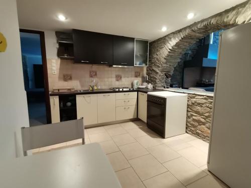 a kitchen with white appliances and a stone wall at Saronic Citadel Seaside villa in Salamís