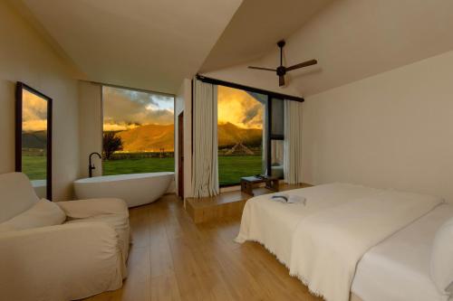 a bedroom with a tub and a bed and a couch at 丽思漫 心宿穹庐四野供氧庄园 in Shangri-La