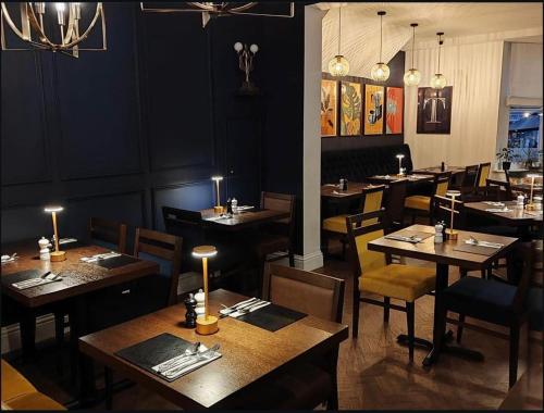 Un comedor con mesas y sillas en un restaurante. en The Bramley House Hotel, en Chatteris