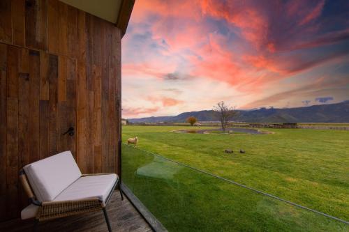 a chair on a porch with a view of a field at 丽思漫 心宿穹庐四野供氧庄园 in Shangri-La