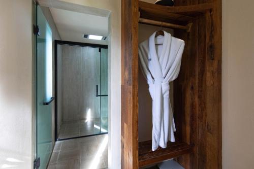 a white robe hanging on a wooden shelf in a bathroom at 丽思漫 心宿穹庐四野供氧庄园 in Shangri-La