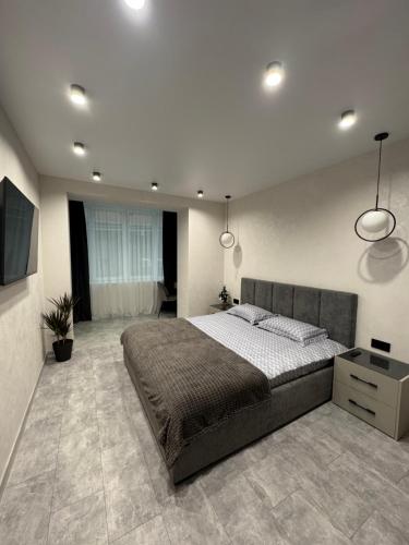 a bedroom with a large bed and a television at Апартаменти Зарічанська вулиця Netflix in Khmelʼnytsʼkyy
