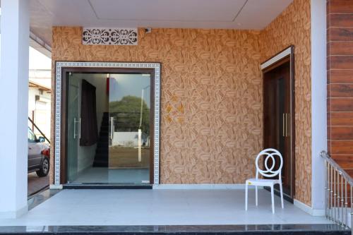 a white chair sitting on the front porch of a house at Hotel Panna Shree in Ujjain
