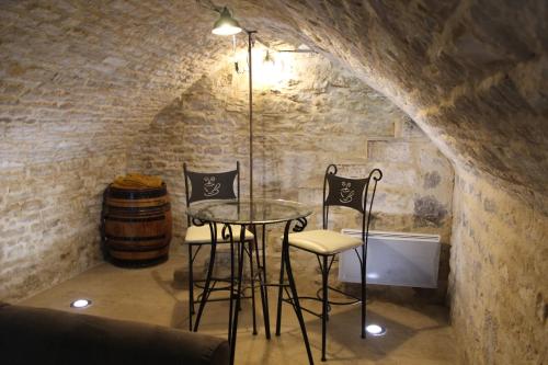 - une cave à vin avec une table, des chaises et un tonneau dans l'établissement Love Loft et Spa, à Ancy-le-Franc