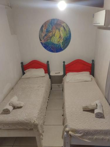 two beds in a room with a painting on the wall at Cabañas con piscina en la entrada de Oberá in Oberá