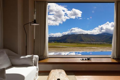 a living room with a large window with a view at 丽思漫 心宿穹庐四野供氧庄园 in Shangri-La