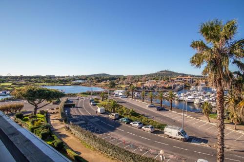 - une vue aride sur un port de plaisance avec des palmiers et des voitures dans l'établissement love secret port nature 7, au Cap d'Agde