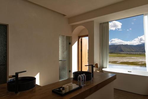 a bathroom with two sinks and a large window at 丽思漫 心宿穹庐四野供氧庄园 in Shangri-La