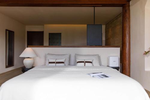 a bedroom with a large white bed with two chairs at 丽思漫 心宿穹庐四野供氧庄园 in Shangri-La