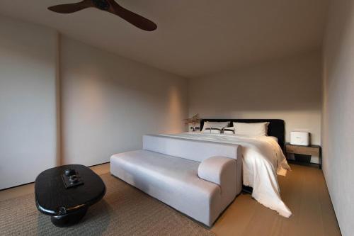 a bedroom with a white bed and a chair at 丽思漫 心宿穹庐四野供氧庄园 in Shangri-La