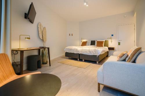 a living room with a bed and a couch at Hotel du Bassin in Ostend