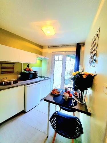 une cuisine avec une petite table et une table sidx sidx sidx sidx dans l'établissement La Petite Boulonnaise Studio cosy avec cour privative - proche Nausicaa, à Boulogne-sur-Mer