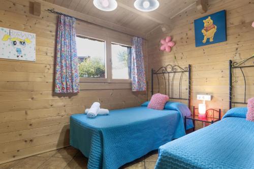 zwei Betten in einem Zimmer mit Holzwänden in der Unterkunft El Refugio de Conil Ideal Familias in Conil de la Frontera