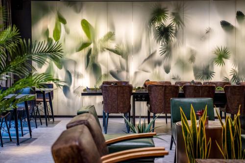 a restaurant with tables and chairs and plants at HeSu Hidden Art Hotel & Suites - Near Bell Tower & Ideal Location-Spacious rooms featuring King or Double Queen beds -Exclusive Two&Three-Bedroom Suites with Expansive Living Rooms for Group Gathering-Kitty Cuddles & Coffee Gift -Seamless Journey Planning in Xi'an